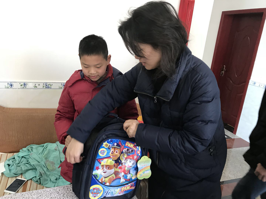 李荣秘书长向贫困学生一一展示书包里的礼物.jpg
